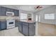 Well-lit kitchen with gray cabinetry, kitchen island and tiled floors at 406 River Glider Ave, North Las Vegas, NV 89084