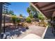 This backyard has brick pavers, a small fire pit, a ' playset, and desert landscaping at 4129 Ridgewood Ave, Las Vegas, NV 89120