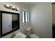 Bathroom featuring an undermount sink, black framed mirror, and window for natural lighting at 4200 Via Vaquero Ave, Las Vegas, NV 89102