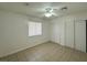 This bedroom features neutral walls, a ceiling fan, and a large window and sliding door closet at 4200 Via Vaquero Ave, Las Vegas, NV 89102