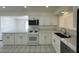 Well-lit kitchen featuring white cabinets, modern appliances, and tile flooring at 4200 Via Vaquero Ave, Las Vegas, NV 89102