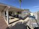View of a backyard with a covered patio, outdoor kitchen area, and gravel groundcover at 4567 S Nellis Blvd, Las Vegas, NV 89121