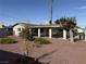 Backyard featuring decorative rock, mature landscaping, and view of the covered patio at 4567 S Nellis Blvd, Las Vegas, NV 89121
