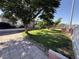 Spacious front yard featuring mature trees, green lawn, and a paved walkway leading to the home's entrance behind a fence at 4567 S Nellis Blvd, Las Vegas, NV 89121