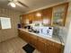 Efficient kitchen with wooden cabinets, tile backsplash, a double sink, and open door for easy access and a cozy feel at 4567 S Nellis Blvd, Las Vegas, NV 89121