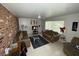 Inviting living room with a brick accent wall, tiled flooring, comfortable seating, and natural light from a large window at 4567 S Nellis Blvd, Las Vegas, NV 89121