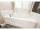 Closeup of a soaking tub in the main bathroom, featuring tile floors and window light at 47 Desert Sunflower Cir, Henderson, NV 89002