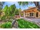 Backyard patio with hot tub, covered patio, lush landscaping, and artificial turf at 5123 Southern Hills Ln, Las Vegas, NV 89113