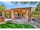 Backyard featuring covered patio, brick pavers, artificial turf and surrounding lush landscaping at 5123 Southern Hills Ln, Las Vegas, NV 89113