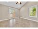 Bright bedroom with tile floors, ceiling fan, backyard views and access to the outdoor space through glass doors at 5123 Southern Hills Ln, Las Vegas, NV 89113