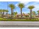 Community entrance featuring lush landscaping, palm trees, and bridge over street at 5123 Southern Hills Ln, Las Vegas, NV 89113