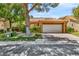 Beautiful home with a lovely front yard, mature trees, and a two-car garage on a sunny day at 5123 Southern Hills Ln, Las Vegas, NV 89113