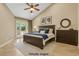 Staged bedroom featuring neutral walls, tile flooring, and a king-size bed with dark wood furniture at 5123 Southern Hills Ln, Las Vegas, NV 89113