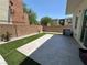 Inviting backyard with artificial turf and rock landscaping, stone patio, and low-maintenance design at 6450 Cinnamon Hazlenut St, North Las Vegas, NV 89084