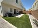 Fully fenced backyard with lush artificial turf, concrete patio, and rock landscaping at 6450 Cinnamon Hazlenut St, North Las Vegas, NV 89084