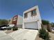 Contemporary two-story home with a large two-car garage and neutral color scheme, near driveway and landscaping at 6450 Cinnamon Hazlenut St, North Las Vegas, NV 89084