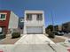 Modern two-story home features a two-car garage and neutral stucco, with a large paved driveway at 6450 Cinnamon Hazlenut St, North Las Vegas, NV 89084