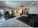 Spacious living room and kitchen features tile flooring, stainless steel appliances, and a large ceiling fan at 6450 Cinnamon Hazlenut St, North Las Vegas, NV 89084