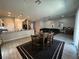 Open floor plan showcasing living room and kitchen with tile flooring, dark area rugs, and stainless steel appliances at 6450 Cinnamon Hazlenut St, North Las Vegas, NV 89084