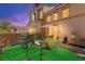 Backyard with artificial turf, patio furniture, and a charming desert landscape at 68 Belle Soleil Ave, Las Vegas, NV 89123