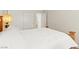 Comfortable bedroom features a wooden bed frame, soft white bedding, and a bright bedside lamp at 68 Belle Soleil Ave, Las Vegas, NV 89123