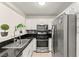 Well-equipped kitchen features stainless steel appliances, dark countertops, and white cabinets for ample storage at 68 Belle Soleil Ave, Las Vegas, NV 89123