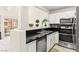 Bright kitchen boasts stainless steel appliances, dark counters, and a view of the outdoor patio area at 68 Belle Soleil Ave, Las Vegas, NV 89123