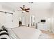 Spacious main bedroom featuring a ceiling fan, barn door, and ensuite bathroom at 68 Belle Soleil Ave, Las Vegas, NV 89123