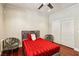 Bedroom features a plush red bed, stylish chairs, and a closet with sliding doors at 691 Vineland Ave, Henderson, NV 89052