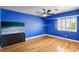 Bedroom featuring sleek hardwood floors, a stylish ceiling fan, and a mounted TV for entertainment at 691 Vineland Ave, Henderson, NV 89052