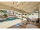 Covered patio featuring comfortable seating, stylish lighting, and a view of the pool for outdoor enjoyment at 691 Vineland Ave, Henderson, NV 89052