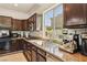 Granite counters and stainless appliances enhance this cozy kitchen with warm wood cabinetry and tile backsplash at 691 Vineland Ave, Henderson, NV 89052