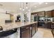 Gourmet kitchen with dark wood cabinetry, granite counters, stainless steel appliances, and center island seating at 691 Vineland Ave, Henderson, NV 89052