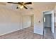 Cozy bedroom showcasing wood floors, a mirrored closet, a ceiling fan, and natural light at 722 Barrie Ct, Henderson, NV 89002