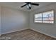 Comfortable bedroom with ceiling fan, wood floors, and a window view of greenery at 722 Barrie Ct, Henderson, NV 89002