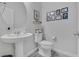 Well-lit half bath with modern fixtures, decorative wall art, and pedestal sink at 7890 S Miller Ln, Las Vegas, NV 89113