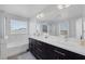Bright bathroom features dual vanities, a large mirror, a soaking tub, and a separate glass-enclosed shower at 7890 S Miller Ln, Las Vegas, NV 89113