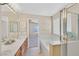 Well-lit bathroom features a dual sink vanity, large mirror, and a soaking tub with a shower at 7920 Turtle Island Ct, Las Vegas, NV 89129