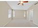 Neutral bedroom features a ceiling fan, carpeting, and many windows, allowing ample natural light at 7920 Turtle Island Ct, Las Vegas, NV 89129