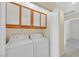 Functional laundry area with front load washer and dryer, complete with upper storage cabinets at 7920 Turtle Island Ct, Las Vegas, NV 89129