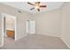 Neutral main bedroom features a ceiling fan, carpeting, and access to the main bathroom at 7920 Turtle Island Ct, Las Vegas, NV 89129