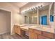 Bright bathroom with dual vanities, wooden cabinets, large mirror and a glass-enclosed shower at 801 Dana Hills Ct # 101, Las Vegas, NV 89134