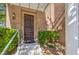 Inviting front entrance with covered porch, brown door, and lush green landscaping at 801 Dana Hills Ct # 101, Las Vegas, NV 89134