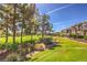 Scenic view of lush green golf course behind townhomes, framed by mature trees, under a clear blue sky at 801 Dana Hills Ct # 101, Las Vegas, NV 89134