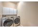 Modern laundry room featuring stainless steel, front load washer and dryer with white cabinets at 801 Dana Hills Ct # 101, Las Vegas, NV 89134