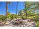 Charming patio with stone table and benches, surrounded by mature landscaping and shade trees on sunny day at 801 Dana Hills Ct # 101, Las Vegas, NV 89134