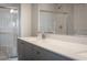 Bathroom with a grey vanity, white countertop, framed mirror, and a glass-enclosed shower at 817 Cottonwood Hill Pl, Henderson, NV 89011