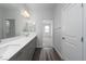 Bathroom with double sinks, white countertop, grey cabinets, and wood-look flooring with a large mirror at 817 Cottonwood Hill Pl, Henderson, NV 89011