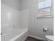 Well-lit bathroom featuring a tiled shower-over-tub, wood-look flooring, and a window with blinds at 817 Cottonwood Hill Pl, Henderson, NV 89011