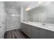 Bathroom featuring a double vanity, a large mirror, and a glass-enclosed shower at 817 Cottonwood Hill Pl, Henderson, NV 89011
